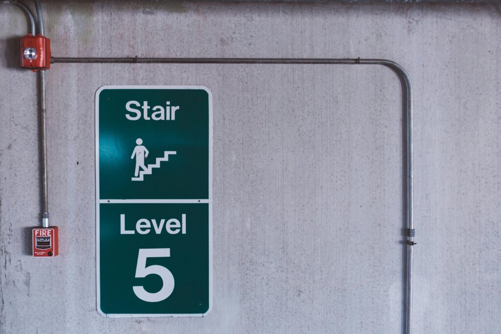 pexels photo 103592 103592 A fire alarm and stair sign on level 5 in an industrial indoor setting.